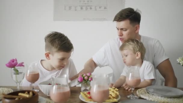 Stilig far och två hans söner äter frukost på morgonen — Stockvideo