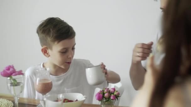 Hijo adolescente desayunando con su familia por la mañana — Vídeo de stock