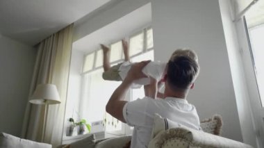 Olumlu bir baba kanepeye oturur ve küçük oğluyla oynar, onu kaldırır.