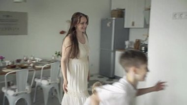 Anne, baba ve iki oğuldan oluşan beyaz bir aile oturma odasında.