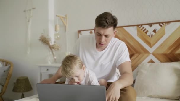 Lindo hijo pequeño y padre adulto aprendiendo a escribir en el cuaderno — Vídeos de Stock