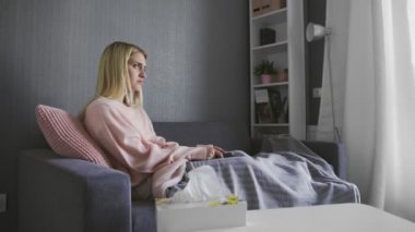 Evde pembe dizi izleyen ve ağlayan genç bir kadın.