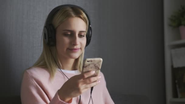 Primo piano della donna con le cuffie che ascolta musica felice e mangia una mela — Video Stock