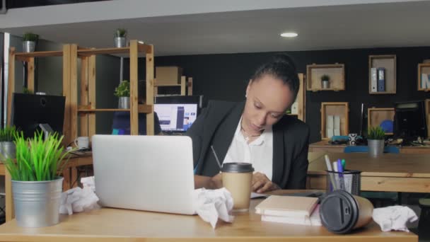 Jeune femme afro-américaine note sur ordinateur portable dans le bureau de coworking — Video