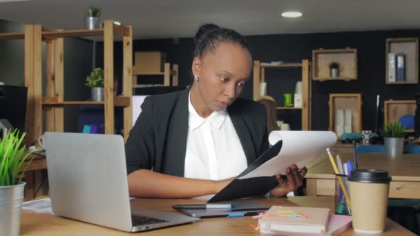 Joven mujer afroamericana trabajando con documentos en la oficina de coworking — Vídeos de Stock