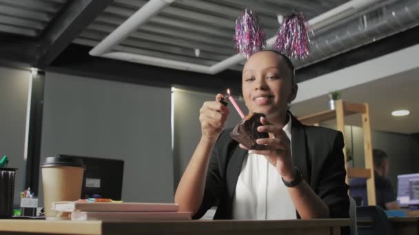Vista de abajo del gerente afroamericano feliz celebrando cumpleaños y pide un deseo en la oficina — Vídeos de Stock