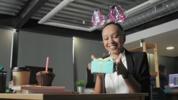 Vista de abajo del gerente afroamericano feliz celebrando cumpleaños y regalo de apertura en la oficina — Vídeo de stock