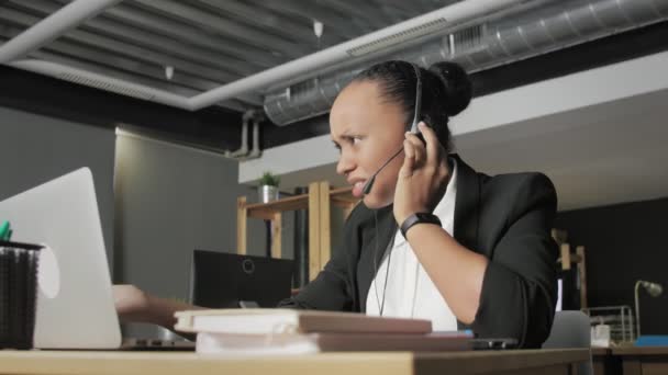 Blick von unten auf andry afrikanisch-amerikanische Frau mit Headset beendet Gespräch mit einem Kunden — Stockvideo