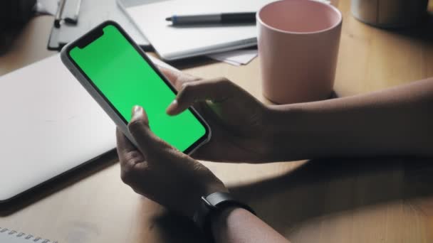 Mujer afroamericana joven usando el teléfono inteligente que ve la pantalla verde en el teléfono móvil — Vídeo de stock