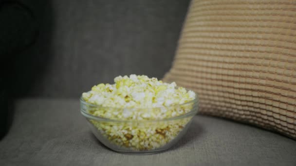 Female hand picking popcorn from paper bucket closeup. — Stock Video