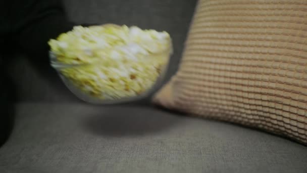 Vrouwelijke hand plukken popcorn van papier emmer close-up. Close-up van een vrouw die popcorn eet in de bioscoop. Movie food concept. Vrouwelijke hand nemen popcorn. — Stockvideo