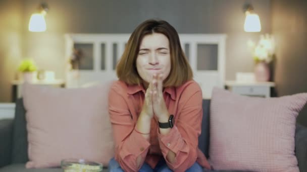 Jeune femme mariée assise sur le canapé, regardant la télévision et tenant la main ensemble — Video