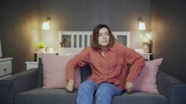 Genç bayan kanepeden kalkar ve gider.