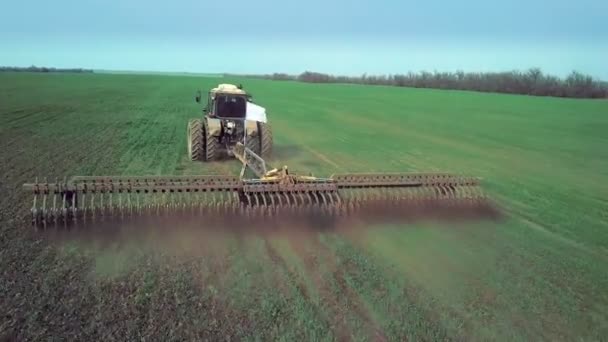 Vue aérienne du labour et de la pulvérisation de tracteurs agricoles sur le terrain — Video