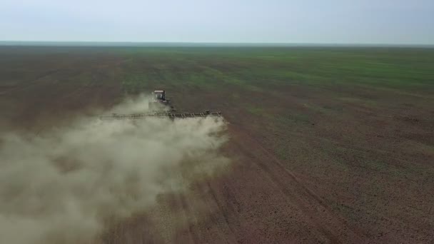 Vue aérienne d'un agriculteur en tracteur préparant des terres agricoles. Vue du haut vers le bas champs de labour tracteur blanc, préparer la terre pour l'ensemencement .