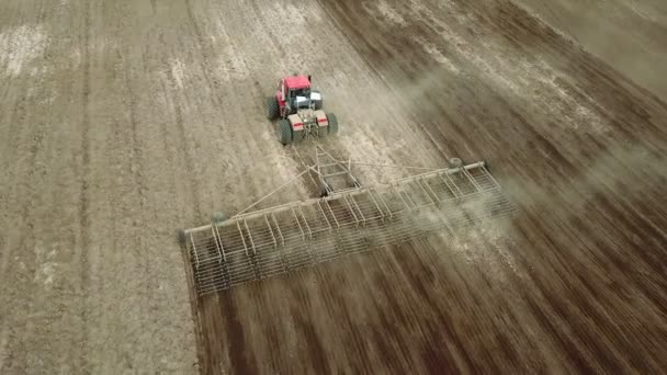 Vue aérienne d'un agriculteur en tracteur préparant des terres agricoles. Vue du haut vers le bas champs de labour tracteur blanc, préparer la terre pour l'ensemencement .