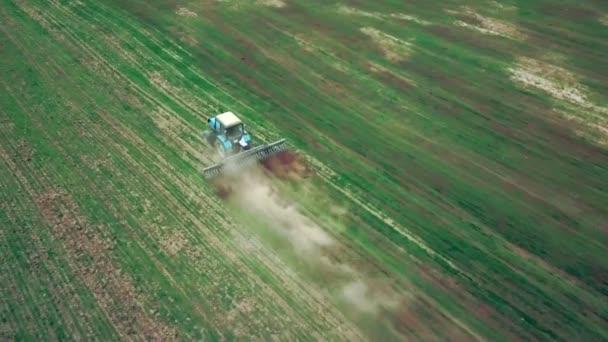 Vista aérea del tractor agrícola arando y pulverizando en el campo — Vídeos de Stock