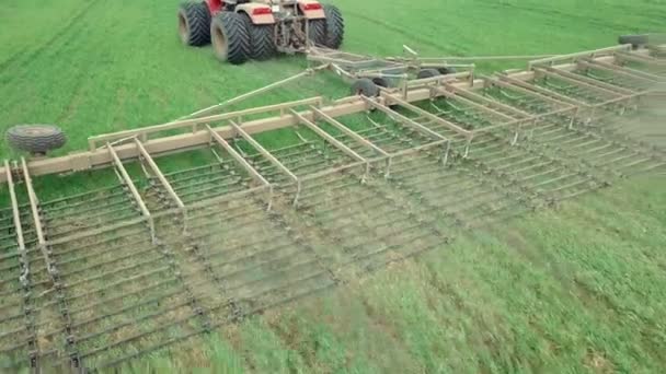 大きなフック力を持つ強力なエネルギー飽和トラクターの空中ビューは、秋にディスク栽培者と冬の作物を播種するための耕作を実行します — ストック動画