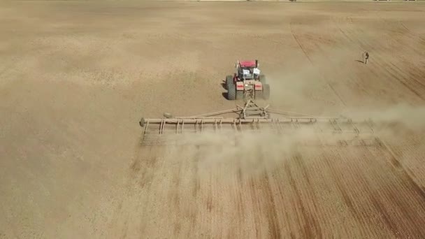 Luchtfoto van een krachtige, met energie verzadigde trekker met een grote haakkracht, die in de herfst met een schijfcultivator teeltmateriaal bewerkt voor het zaaien van wintergewassen — Stockvideo