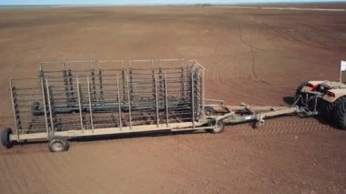 Drone, fermer traktörün etrafında uçuyor. Sahada daire çiziyor.