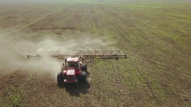 Vue aérienne d'un puissant tracteur saturé d'énergie avec une grande force de crochet, effectuant du travail du sol pour semer des cultures d'hiver avec un cultivateur à disques à l'automne 