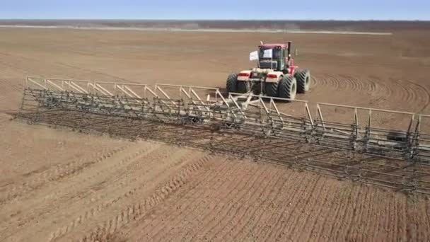 Bovenaanzicht vanuit de lucht van een oogstmachine die haver oogst in een landbouwbedrijf. — Stockvideo