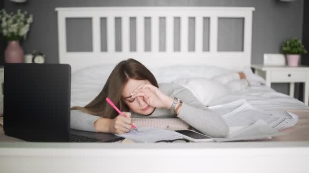 Estudante preguiçosa tenta estudar, mas adormece na cama — Vídeo de Stock