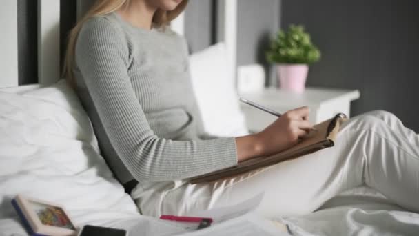 Diseñadora femenina trabajando en casa. Joven pintor escribiendo bocetos en la cama por la mañana. Dibujo de chica creativa ilustración — Vídeo de stock