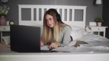 Evde öğrenim gören konsantre bir kız öğrenci, online eğitim.