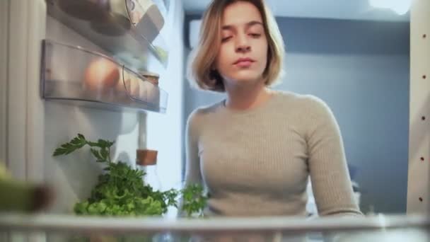 Vista desde el interior del refrigerador mientras la mujer abre la puerta y bebe agua de la botella — Vídeos de Stock