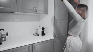 Kadın sabah mutfaktaki buzdolabının kapısını açıp esniyor.