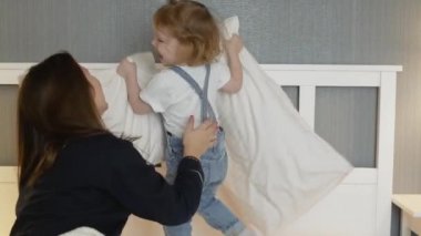 Anne yatakta tatlı küçük kızıyla oynuyor.