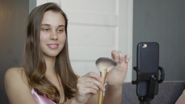 Beauty-Bloggerin präsentiert Schönheitskosmetik, während sie vor der Kamera sitzt, um Video aufzunehmen. — Stockvideo