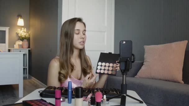 Joven blogger grabando video vlog con maquillaje cosmético en casa influencer online en concepto de redes sociales . — Vídeo de stock
