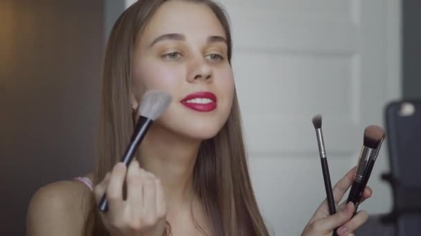Primer plano de la mujer hermosa uso cepillo mientras que la revisión de maquillaje tutorial de difusión de vídeo en vivo a la red social por Internet . — Vídeo de stock