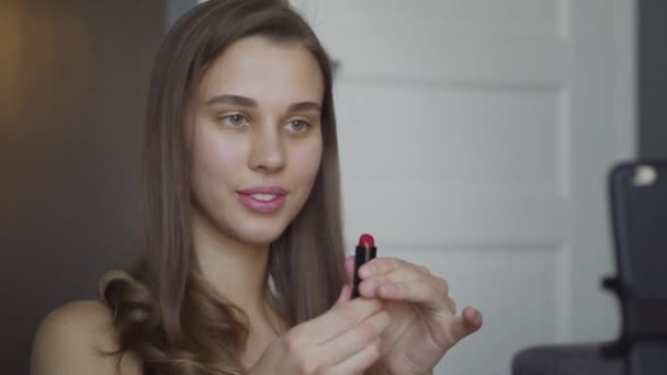 Junge Bloggerin mit Pinsel und rosa Lippenstift Make-up. schöne Frau zeigt Kosmetik und Lippen im Live-Shop Online-Video-Streaming. — Stockvideo