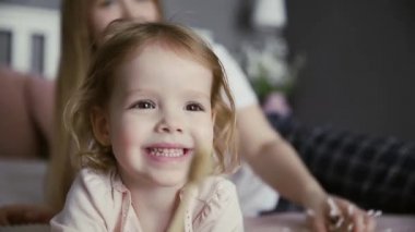 Küçük kız dişlerini ve dilini bambu bir diş fırçasıyla fırçalıyor.