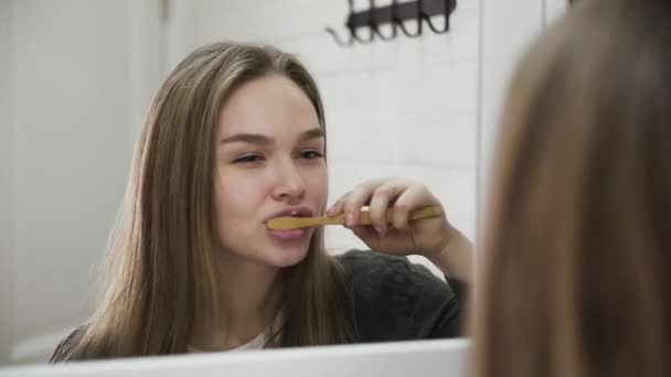 Mujer joven y un cepillo de dientes de madera. Concepto de estilo de vida de cero residuos de sustituir los residuos de vertederos de plástico por opciones ecológicas . — Vídeos de Stock