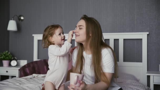 快乐的年轻妈妈和可爱可爱的小可爱的幼儿女儿玩耍。小女孩玩棉签 —— 库存视频 © stanis88 #364336486