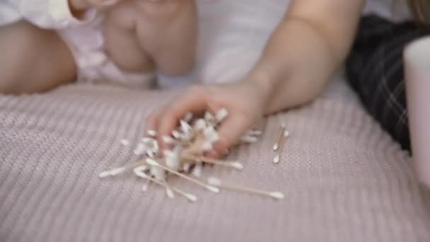 Primer plano de la madre y su hija pequeña juega con hisopos de algodón — Vídeos de Stock