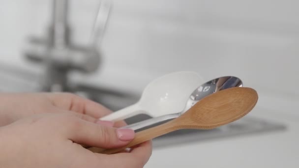 Woman holds plastic, metal and bamboo spoon. Woman choose a bamboo spoon — Stock Video