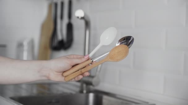 Woman holds plastic, metal and bamboo spoon. Woman choose a bamboo spoon — Stock Video