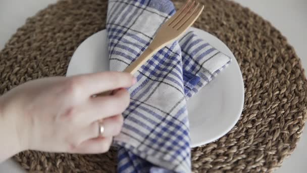 Woman puts wooden spoon and fork on a cloth napkin — Stock Video