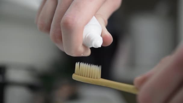 Primer plano del hombre pone pasta de dientes en el cepillo de dientes — Vídeos de Stock