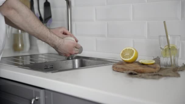 Primo piano dell'uomo pulisce con una spugna bianca in cucina — Video Stock