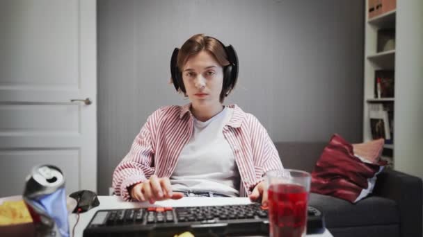 Молодая женщина играет в видеоигры на своем компьютере дома — стоковое видео