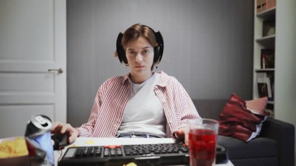 Профессиональная женщина-геймер играет в видеоигры на своем компьютере дома — стоковое видео