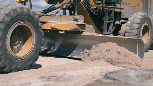 Cesta funguje. Detailní záběr traktoru vyrovnávání země ve venkovské krajině. — Stock video