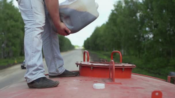 Arbeiter gießt Bitumen oder Öl in den Tank — Stockvideo