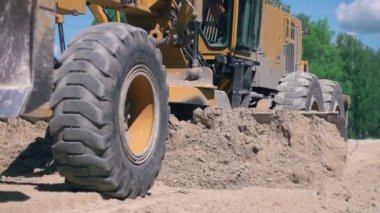 Yol çalışıyor. Traktör kırsal alanda zemini düzleştiriyor. Yavaş çekim